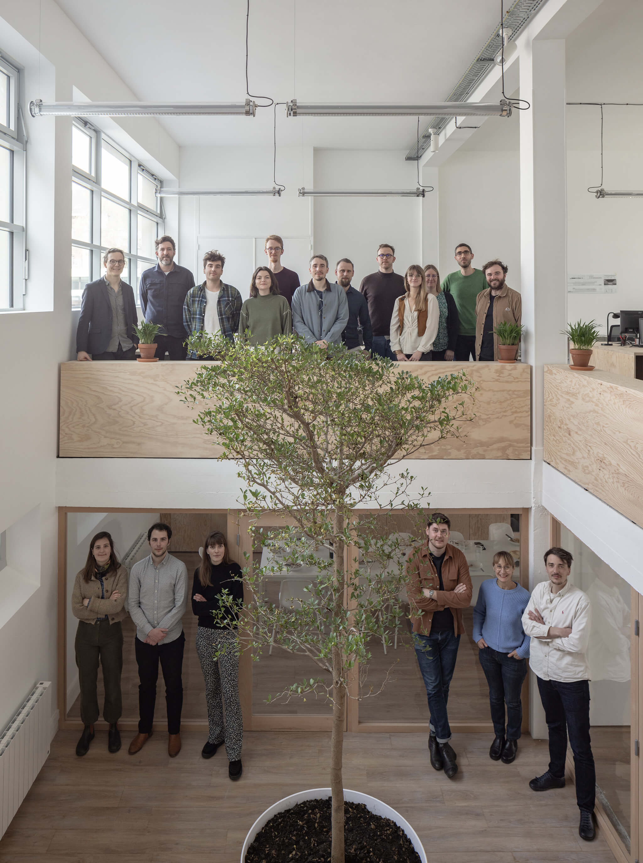 Photographie de l'équipe ACAU Architectes répartie sur les deux niveaux de l'agence